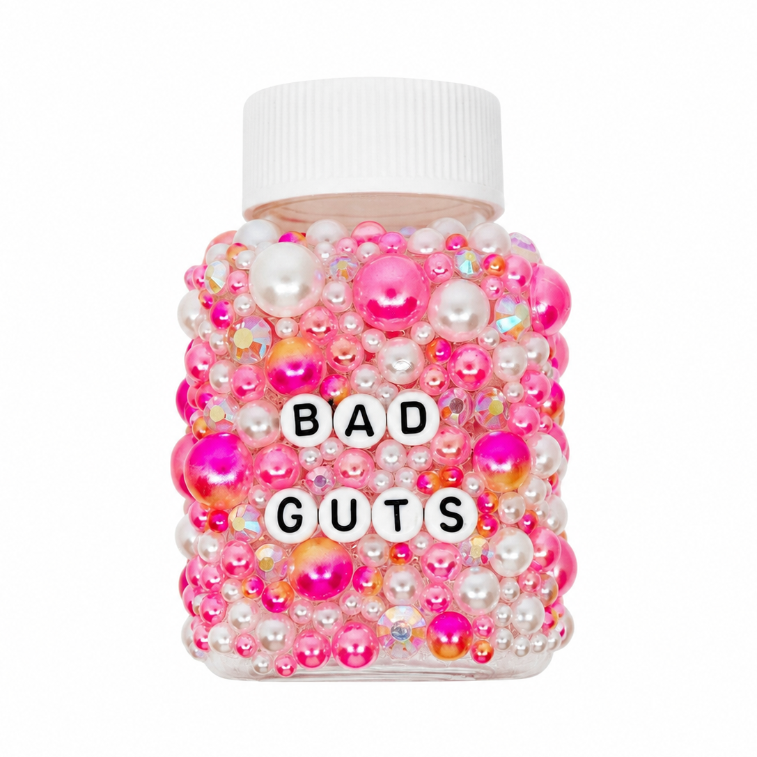Jar labeled 'BAD GUTS' covered in colorful beads on a white background