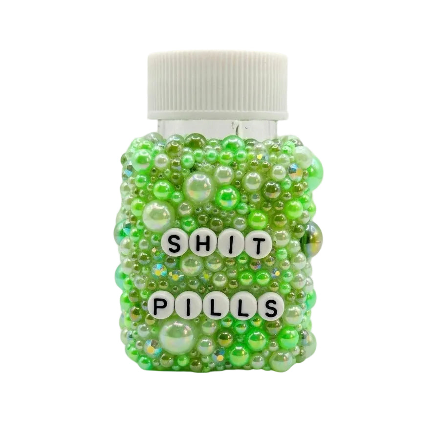 Jar filled with green beads and labeled 'SHIT PILLS' on a white background